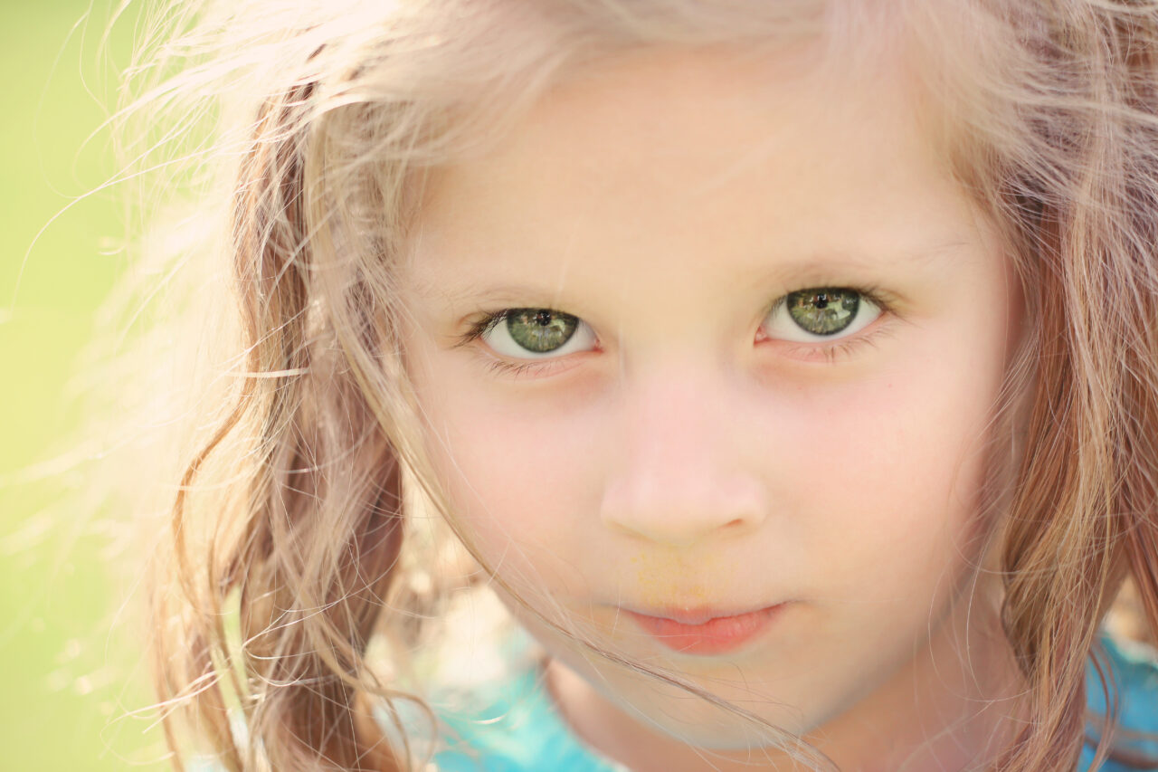 A close up of a small girl outside in natural light