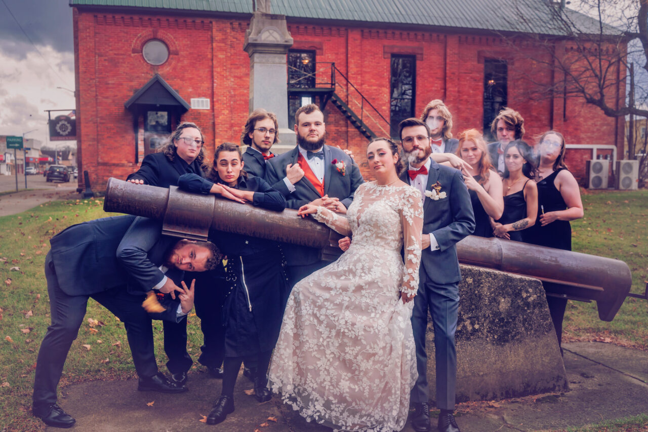 A bridal party posed around an historic canon in Lawton Michigan outside of Red Brick Hall